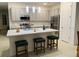 Bright kitchen featuring a quartz countertop island with bar stool seating, stainless appliances, and grey backsplash at 726 Longboat, Davenport, FL 33896