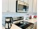 Modern kitchen features stainless steel appliances, mosaic tile backsplash, and white cabinets at 726 Longboat, Davenport, FL 33896