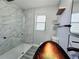 Bathroom featuring a tiled shower with modern fixtures and glass door, complemented by wood-look flooring for a luxurious feel at 726 Marion Oaks Ln, Ocala, FL 34473