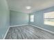 Bedroom features sleek wood-look flooring, two bright windows, and neutral paint, offering a versatile and welcoming space at 726 Marion Oaks Ln, Ocala, FL 34473