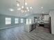 Bright, spacious kitchen and living area with modern light fixture, gray cabinets, and stainless appliances at 726 Marion Oaks Ln, Ocala, FL 34473
