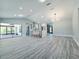 Open concept living room with grey wood floors, a vaulted ceiling, and open access to the kitchen at 726 Marion Oaks Ln, Ocala, FL 34473