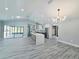 Spacious living area with vaulted ceiling, contemporary lighting fixture, and an open view of the modern kitchen at 726 Marion Oaks Ln, Ocala, FL 34473