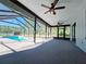 Covered, screened patio with ceiling fans overlooking a pool and outdoor scenery, creating an ideal space for leisure at 726 Marion Oaks Ln, Ocala, FL 34473