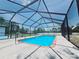 A serene screened-in pool with clear blue water offers a private oasis for swimming and leisure at 726 Marion Oaks Ln, Ocala, FL 34473