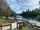 Scenic river view with wooden walkways, docks and lush green trees on a bright sunny day at 726 Marion Oaks Ln, Ocala, FL 34473