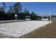 Community sand volleyball court featuring white sand, net, covered benches, and surrounding green spaces at 726 Marion Oaks Ln, Ocala, FL 34473