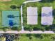 Aerial view of a basketball court and two beach volleyball courts surrounded by green grass and palm trees at 7527 Marker Ave, Kissimmee, FL 34747