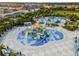 Aerial view of community splash pad with water slides and lounge chairs for Gathering fun in the sun at 7527 Marker Ave, Kissimmee, FL 34747