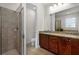 Bathroom featuring a tiled shower, dark wood cabinets and granite countertop with double sinks at 7527 Marker Ave, Kissimmee, FL 34747