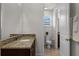 Bathroom featuring granite countertops, neutral tile floor, and a bright window for natural light at 7527 Marker Ave, Kissimmee, FL 34747