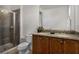 Bathroom with a tiled shower, dual sinks, dark wood cabinets and granite countertops at 7527 Marker Ave, Kissimmee, FL 34747