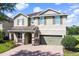 Attractive two-story home featuring brick-paved driveway and a well-maintained lawn and shrubbery at 7527 Marker Ave, Kissimmee, FL 34747