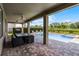 View of a patio with a dining table and chairs. In the background is a pool and lush landscaping at 7527 Marker Ave, Kissimmee, FL 34747