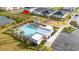 Aerial view showcases community amenities: pool, playground, parking, and proximity to pond and residential houses at 8967 Chipping Square Ln, Davenport, FL 33896