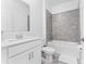 Modern bathroom featuring tiled shower, sleek vanity, and white tiling at 8967 Chipping Square Ln, Davenport, FL 33896