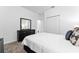 Carpeted bedroom with a dresser and large mirror and a comfortable bed with modern decor at 8967 Chipping Square Ln, Davenport, FL 33896
