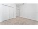 Bright bedroom featuring plush carpeting, closet doors, and a white interior at 8967 Chipping Square Ln, Davenport, FL 33896