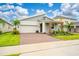 Inviting single-story home with a two-car garage and nicely manicured lawn and plants at 8967 Chipping Square Ln, Davenport, FL 33896