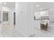 Hallway leading to kitchen and bathroom with modern tiled floors, white walls, and bright interior at 8967 Chipping Square Ln, Davenport, FL 33896