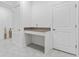 Home office with tiled floor, built-in desk area, bright white walls, and a small window at 8967 Chipping Square Ln, Davenport, FL 33896