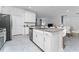 Open-concept kitchen with a gray island, stainless appliances, and seamless flow at 8967 Chipping Square Ln, Davenport, FL 33896