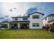 Spacious backyard with lush green grass, covered patio, and modern home exterior at 9004 Santorini Dr, Orlando, FL 32827