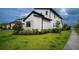 Modern home exterior featuring a well-manicured lawn, stone accents, and dark trim at 9004 Santorini Dr, Orlando, FL 32827