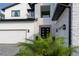 Elegant modern home with stone details, lush landscaping, and a stylish, inviting front entrance at 9004 Santorini Dr, Orlando, FL 32827