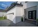 Home's front entrance features a modern door, stone accents, and a paved driveway at 9004 Santorini Dr, Orlando, FL 32827