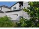 Contemporary home featuring a pristine white facade, a two-car garage, and lovely tropical landscaping at 9004 Santorini Dr, Orlando, FL 32827
