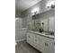Bathroom featuring double sinks with granite countertops and bright vanity lighting at 9318 Mclaren Aly, Winter Garden, FL 34787