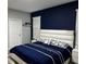 Comfortable bedroom featuring stylish blue bedding, a padded headboard, and abundant natural light at 9318 Mclaren Aly, Winter Garden, FL 34787