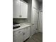 Hallway featuring white cabinets, countertops, and modern flooring at 9318 Mclaren Aly, Winter Garden, FL 34787