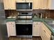 Galley kitchen featuring updated stainless steel appliances and copper-colored backsplash at 940 Fenton Ln # 8, Lakeland, FL 33809