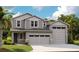Charming two-story home featuring a three-car garage, stone accents, and lush landscaping at 1038 Wisteria Way, Dundee, FL 33838