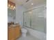 Neutral bathroom featuring a granite vanity, shower with glass doors, and mosaic-tile accent mirror at 1101 Marcello Blvd, Kissimmee, FL 34746