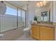 A bright bathroom with granite countertop, shower with glass doors, and light wood cabinets at 1101 Marcello Blvd, Kissimmee, FL 34746