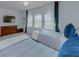 Bright bedroom with dual twin beds, a dresser, TV, and large windows with sheer curtains at 1101 Marcello Blvd, Kissimmee, FL 34746