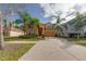 Charming two-story home with a well-manicured lawn and mature trees on a sunny day at 1101 Marcello Blvd, Kissimmee, FL 34746