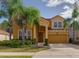 Charming two-story home with a two-car garage and beautiful landscaping, including lush palm trees at 1101 Marcello Blvd, Kissimmee, FL 34746