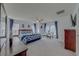Bright main bedroom with a ceiling fan, large windows with blue curtains, and a modern flat-screen TV at 1101 Marcello Blvd, Kissimmee, FL 34746