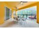 Bright, covered patio with a dining table, fan, and view of the screened-in pool and backyard at 1101 Marcello Blvd, Kissimmee, FL 34746