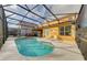 Screened-in pool area with a clear blue pool, spa, and lounge chairs on the deck at 1101 Marcello Blvd, Kissimmee, FL 34746