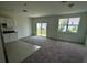 Bright living room featuring carpeted flooring, large windows, and sliding glass door to backyard at 1140 Merrill St, Davenport, FL 33837