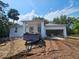 Contemporary home under construction with an attached garage and covered entryway, set against a clear blue sky at 1400 Conrad Dr, New Smyrna Beach, FL 32168