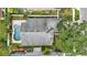 An aerial perspective showcases the house roof, pool, deck, fence and lush yard in a neighborhood setting at 14006 Yellow Wood Cir, Orlando, FL 32828