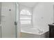 Bathroom with a separate shower and bathtub combo under an arched window at 14006 Yellow Wood Cir, Orlando, FL 32828
