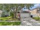 Front exterior featuring a two-car garage, manicured lawn and landscaping at 14006 Yellow Wood Cir, Orlando, FL 32828