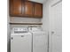 Laundry room with a washer and dryer, cabinet storage, and open shelf at 14006 Yellow Wood Cir, Orlando, FL 32828